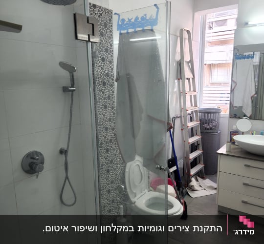 מקלחת זכוכית עם ראש מקלחת וכיור ליד.